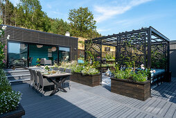 Modern, outdoor living space with grey floor, pergola and summerhouse