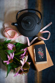 Black teapot, ribbons, Echinaceas, book and cross-stitch mobile phone case