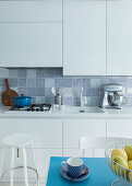 White fitted kitchen with tiled splashback