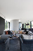Sofa and armchairs in luxurious open-plan interior in shades of grey