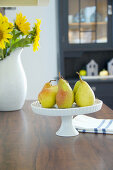 Pear on cake stand on dining table