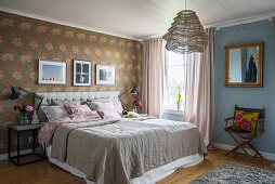 Vintage-style wallpaper and blue wall in classic bedroom