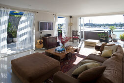 Wohnraum mit brauner Polstergarnitur und weitgeöffneten Terrassentüren