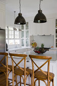 Bentwood barstools at island counter in white, modern, country-house kitchen