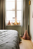 Christmas decorations and honeycomb paper Christmas trees in bedroom in muted shades