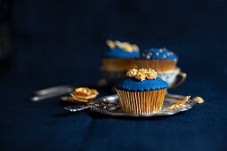 Perfectly decorated cupcakes with blue and gold toppings