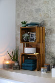 DIY shelves making from wooden crates in bathroom with stone wall