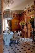 Flower arrangements, wood-panelled walls and hunting trophies in stylish dining room
