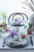 Table set for Easter in natural style with eggs and dyed grasses
