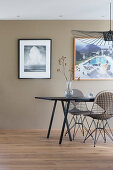 Esstisch mit Designerstühlen und Fotokunst an schlammfarbener Wand