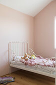White bed in child's bedroom with pink walls