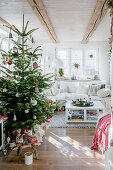 Weihnachtsbaum im sonnigen Wohnzimmer im Landhausstil