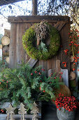 Christmas decoration with moss wreath, box with twigs and rose hips