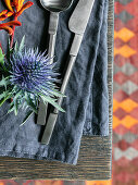Thistle and cutlery on blue-grey linen napkin