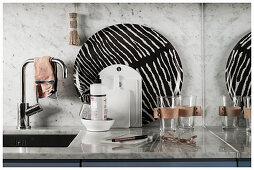 Glasses, chopping boards and zebra-patterned tray next to sink