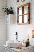 Waschtisch mit rundem Waschbecken im Bad mit weißer Holzwand