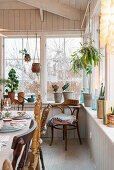 Rustic vintage-style decorations and plants around dining table in conservatory