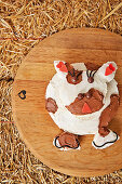 Two-tiered cake with cow's face covered in white and brown buttercream