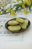 Bowl of pistachio biscuits on sheet music