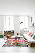 Sofa aus Paletten im Wohnzimmer mit weißem Boden und Farbakzenten