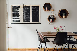 Chalkboard wall planner and hexagonal shelf modules above table