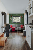 Kariertes Sofa vor grüner Wand und Ofen im Tiny House