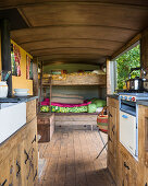 Hochbett und Küche im rustikalen Tiny Home mit Holzboden