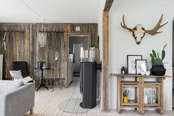 Hunting trophy and workbench in rustic living room with board wall