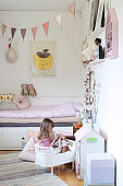 Girl playing in pretty, pink-and-white bedroom