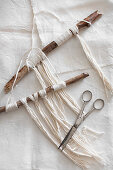 Wall hanging made from sticks and woollen yarn macrame