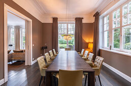 Elegantes Esszimmer in Brauntönen mit langem Holztisch und Lederstühlen