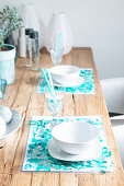 Handmade place mats with turquoise watercolour effect on wooden table