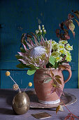 Autumn bouquet of protea, chrysanthemums, tendril of Virginia creeper, dogwood and St. John's wort with white berries
