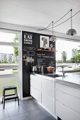 Chalkboard wall in modern kitchen with floor-to-ceiling windows