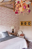 Eccentric chandeliers in shades of pink in bedroom with toile de jouy wallpaper