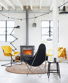 Outdoor chairs in black and yellow in front of wood burner in living room