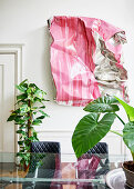 Aluminium artwork on wall, houseplants, glass table and chairs