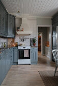 Grey cupboards in rustic kitchen-dining room in country-house style