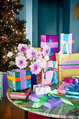 Colourfully wrapped gifts with glittering paper and bouquet of dahlias