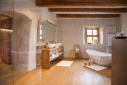 Free-standing bathtub in large bathroom of rustic farmhouse