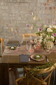 Flower arrangement on set table with eggs in twig nests on plates