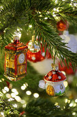 Christmas-tree decorations in shape of fly agaric mushroom and clock tower surrounded by sparkling lights
