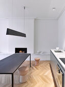 Kitchen counter, table and fireplace in modern minimalist interior