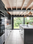 Modern kitchen with grey panelled cabinets and wooden ceiling