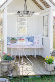 Pretty cushions on bench in arbour with small deck