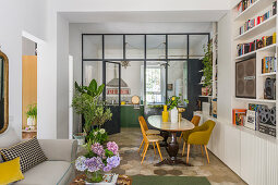 Offener Wohnraum mit Wohn- und Essbereich und Glaswand zur Küche