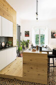 Modern, open-plan wooden kitchen with Italian tiled floor