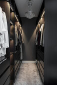 Walk-in wardrobe with dark cabinets and pale carpet
