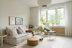 Sofa with loose linen cover in bright living room