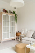 Cupboard with fabric-covered doors made from old windows in living room corner